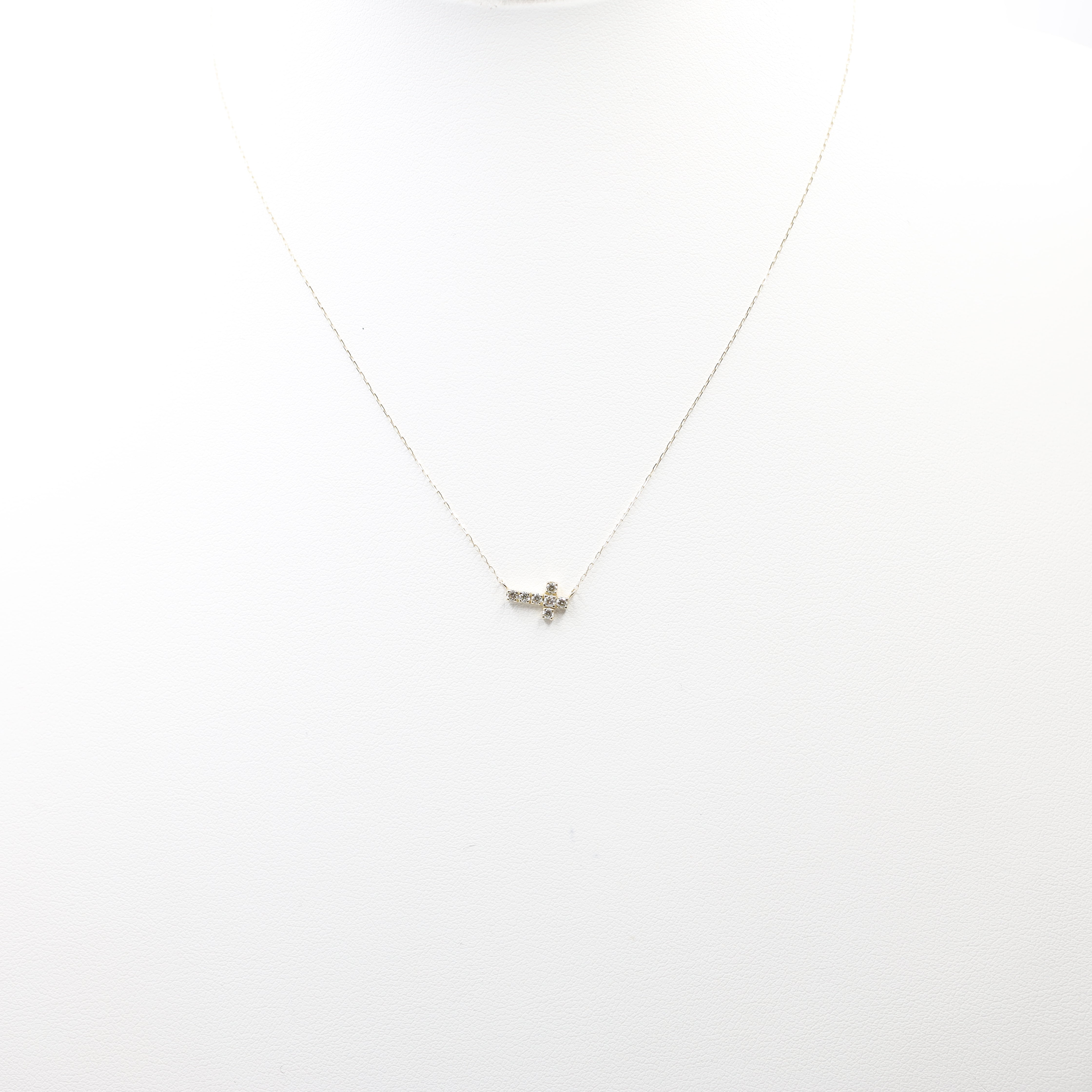 An exquisite and minimalist cross necklace, perfect for daily wear or layering. Crafted from 18K yellow gold, this dainty piece features sparkling diamonds for a subtle touch of luxury.