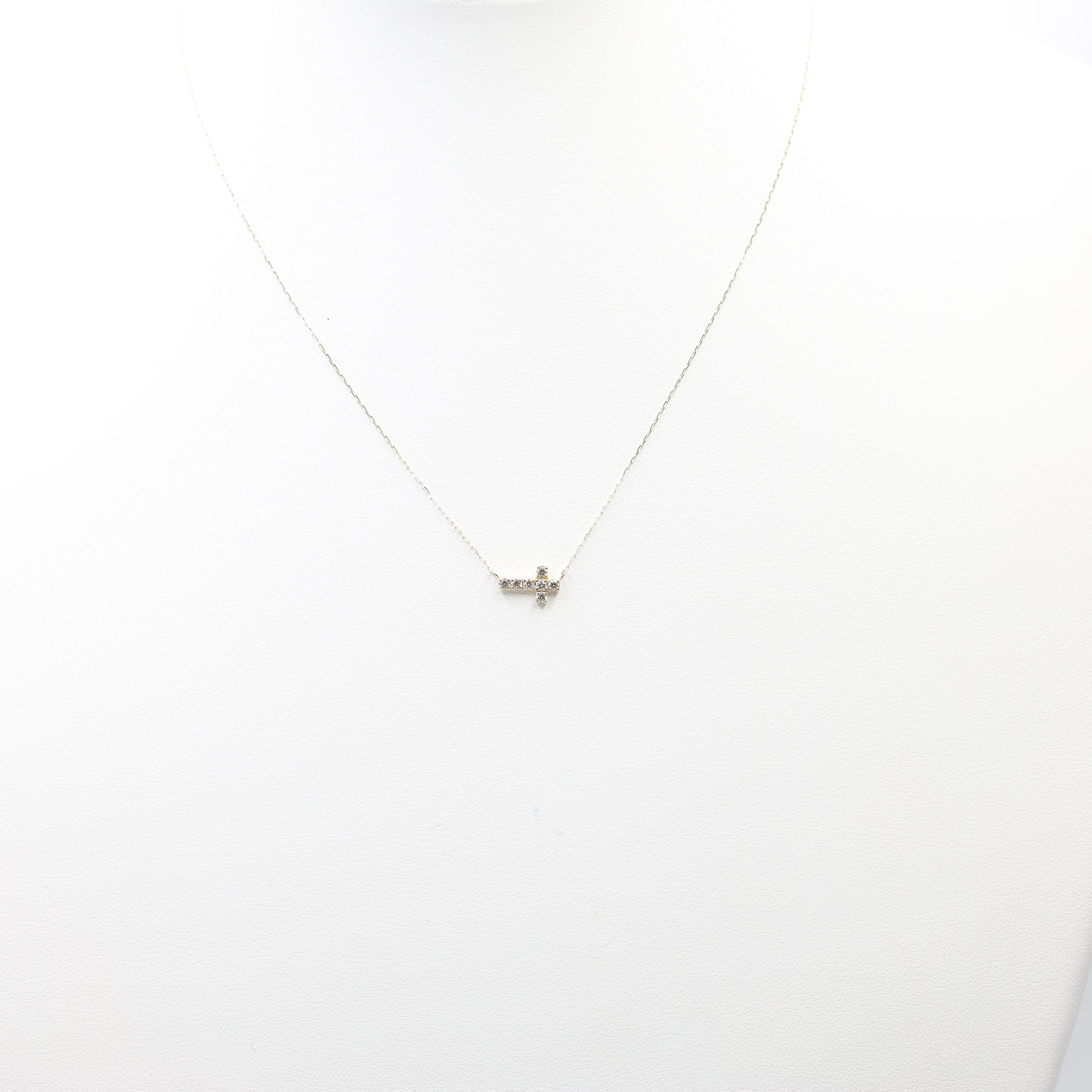 An exquisite and minimalist cross necklace, perfect for daily wear or layering. Crafted from 18K yellow gold, this dainty piece features sparkling diamonds for a subtle touch of luxury.