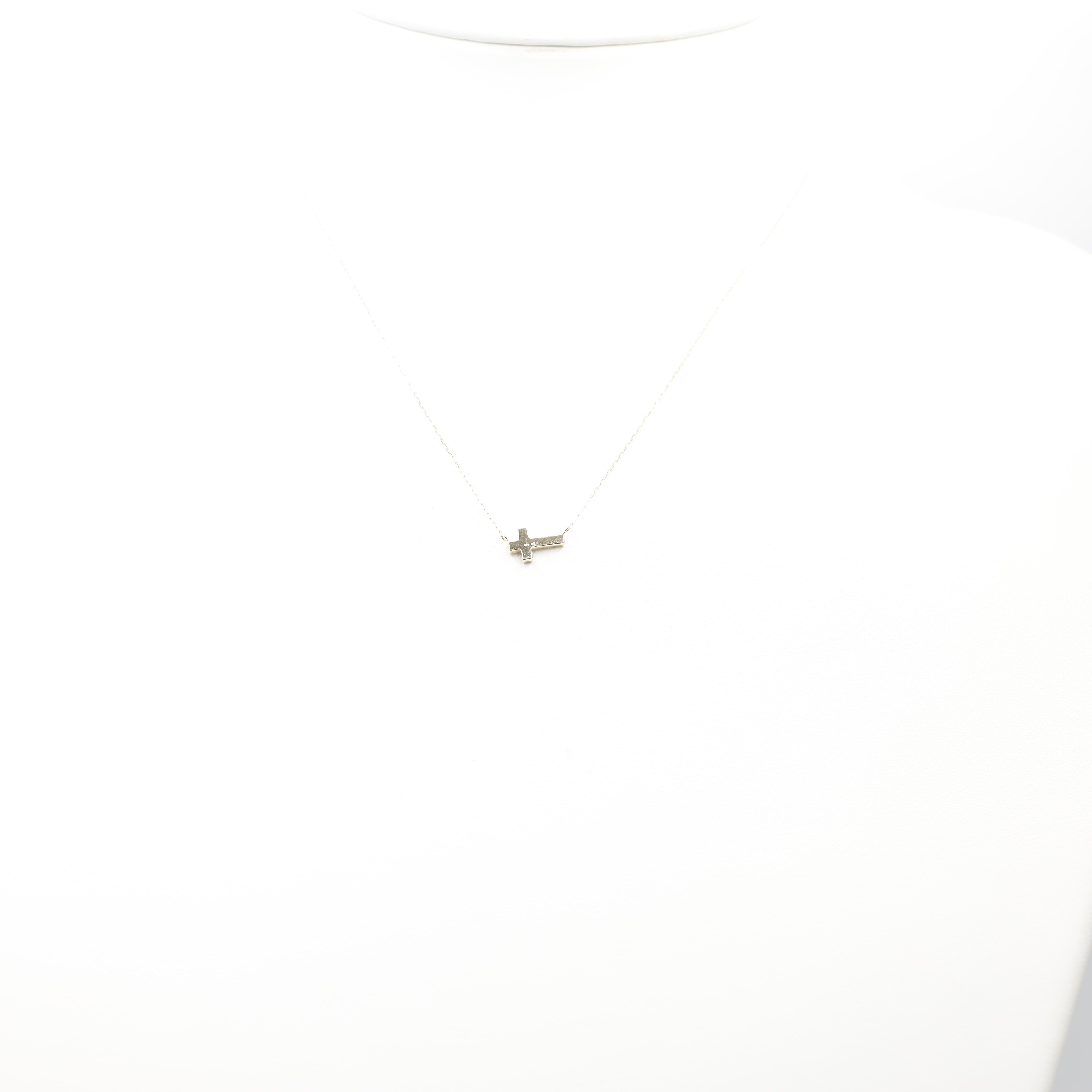 An exquisite and minimalist cross necklace, perfect for daily wear or layering. Crafted from 18K yellow gold, this dainty piece features sparkling diamonds for a subtle touch of luxury.