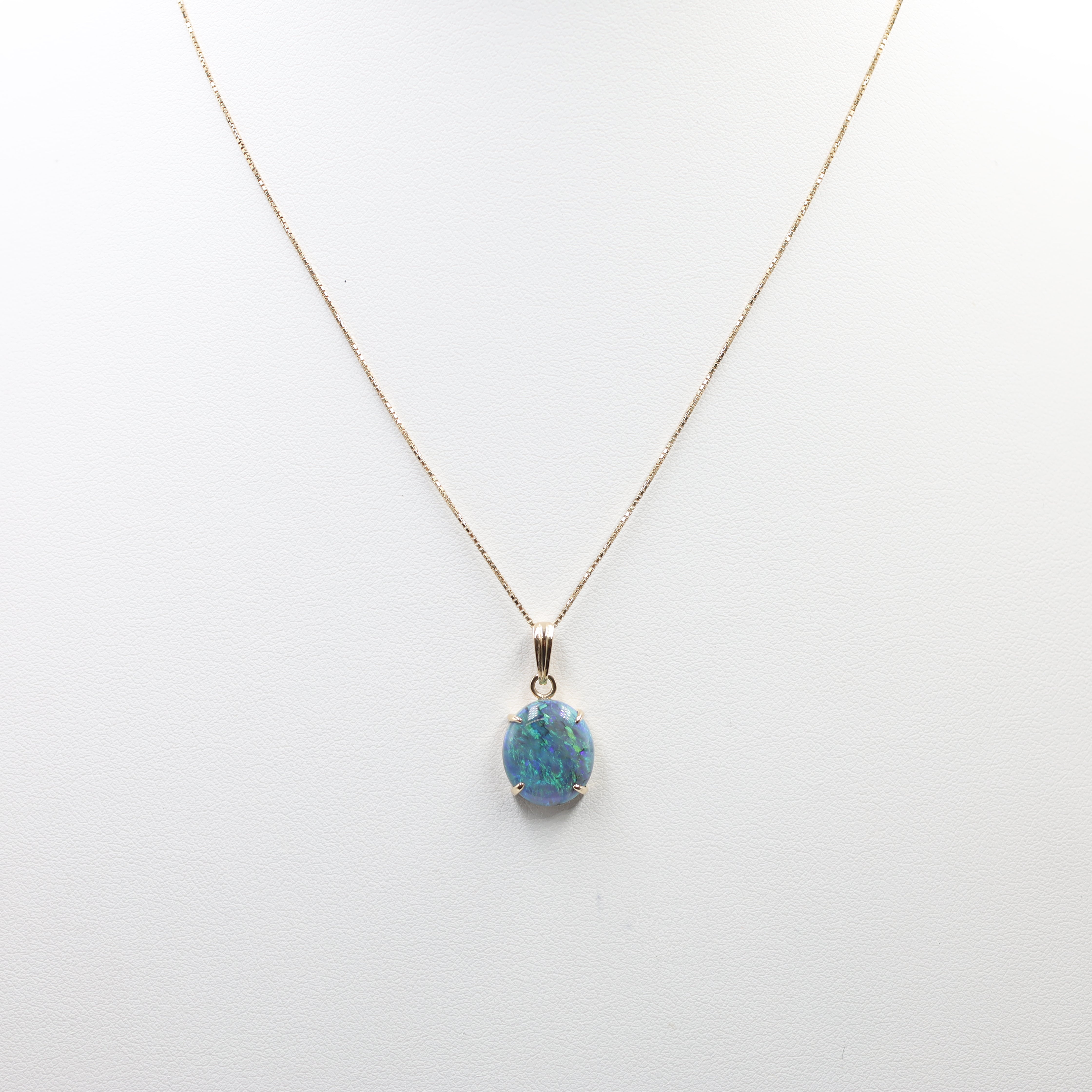 This is an elegant Opal Necklace featuring a striking oval-cut opal pendant suspended from a fine chain. The setting and chain are crafted from 18K Yellow Gold (YG). The key features include: