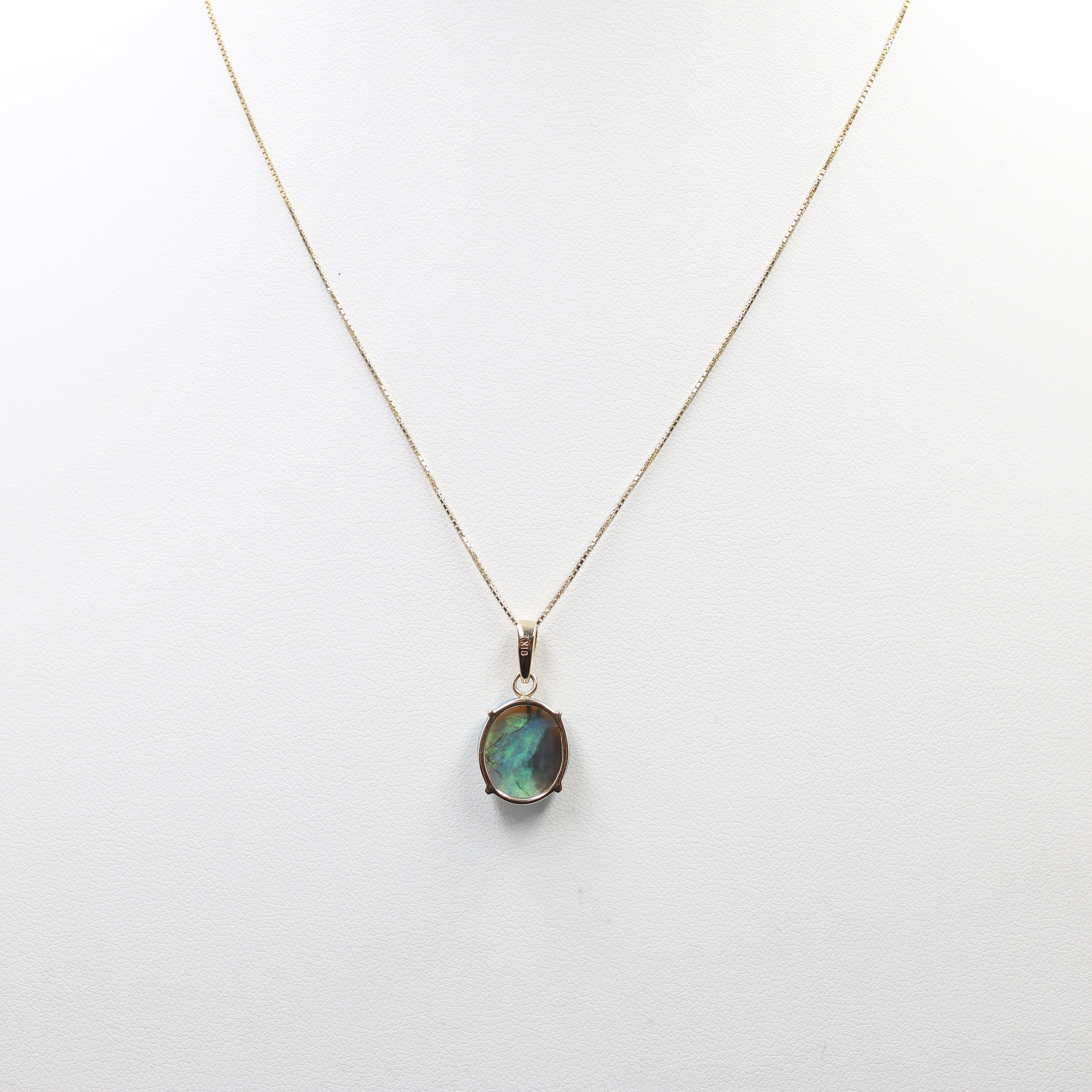 This is an elegant Opal Necklace featuring a striking oval-cut opal pendant suspended from a fine chain. The setting and chain are crafted from 18K Yellow Gold (YG). The key features include: